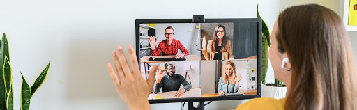 A woman having a video call, waving in front of the camera