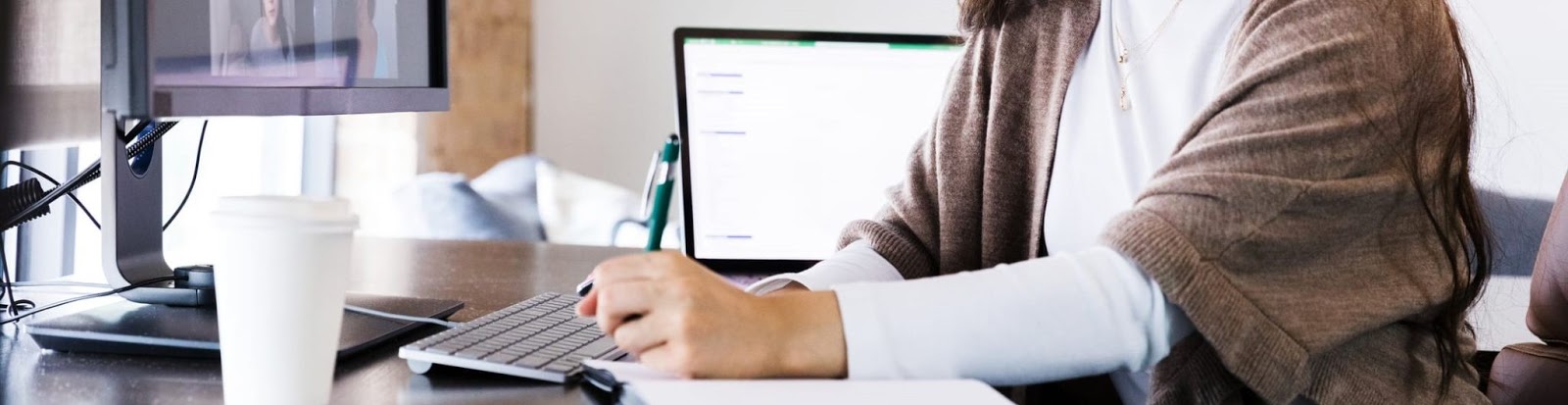 A girl writing in front of the computer