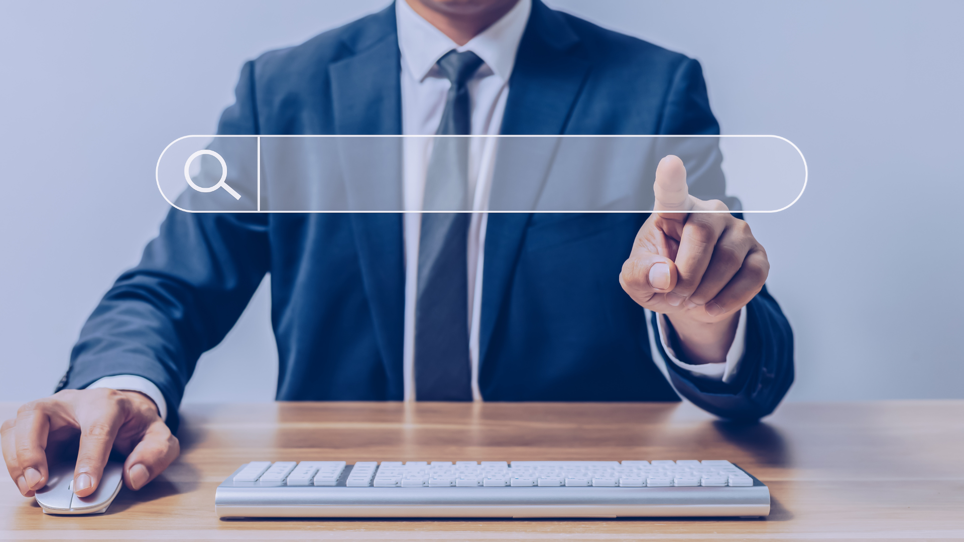 Professional in a suit using a computer and pointing at a virtual search bar, symbolizing online visibility, job search, and building a strong digital portfolio.