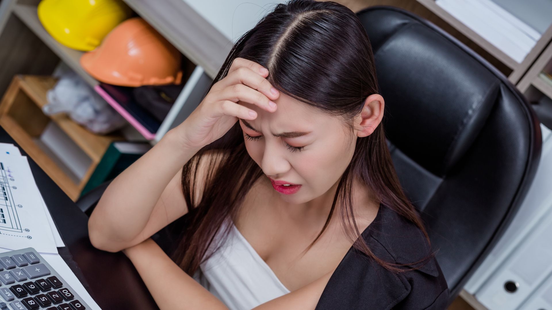 Employee holding head due to stress