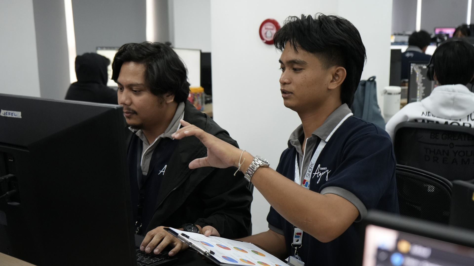 Filipino BPO agents working at a desk with a computer, representing the entry-level clerical roles most exposed to the AI skills gap.